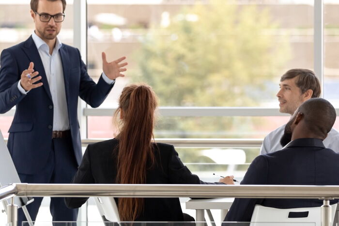 Ein Mann steht vor einer Gruppe und hält einen Vortrag