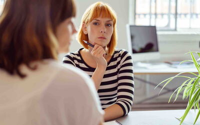 Nachdenkliche Frau im Büro wirkt unglücklich im Job – Symbolbild für Unzufriedenheit am Arbeitsplatz ohne Alternative