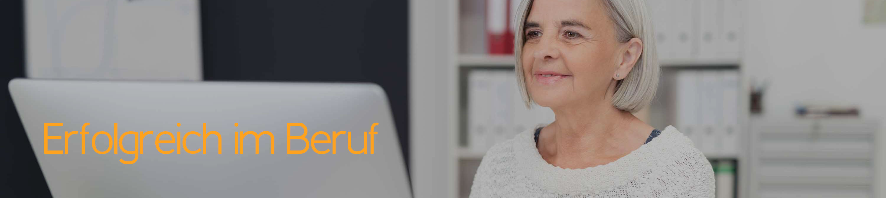 Eine Frau sitzt vor einem Computer und schaut auf den Monitor. Erfolg im Beruf.